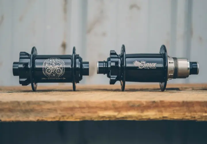 Two black Onyx Vesper hubs, one with a skull and bike graphic, the other with the Onyx logo, ready for a review.