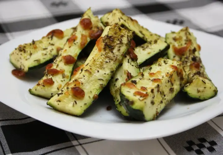 Delicioso calabacín al horno, cortado en bastones y cubierto con queso derretido y hierbas aromáticas.