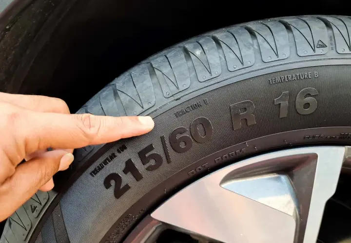 Palec wskazujący na oznaczenie opony 215/60 R16.