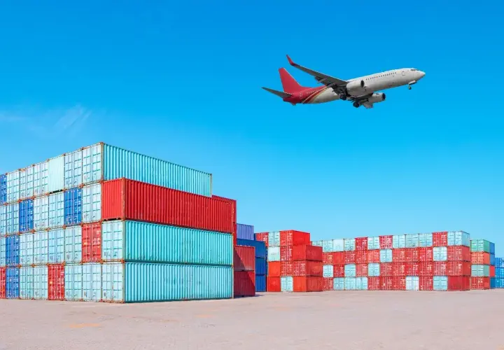 Frachtflugzeug über Containerstapeln. Die IATA Bedeutung für globalen Handel wird hier visuell dargestellt.