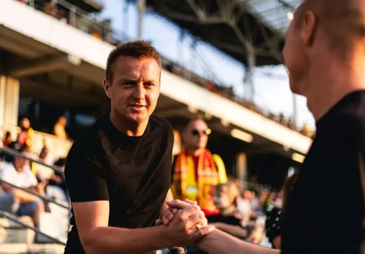 Trener Stali Mielec wita kibica na stadionie.