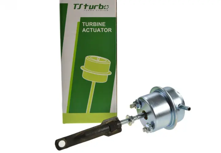 Zawór podciśnienia turbiny Ford Focus 1.6 TDCI. Element metalowy z grzybkiem i regulowanym ramieniem, obok zielono-białe opakowanie z napisem "TURBINE ACTUATOR".