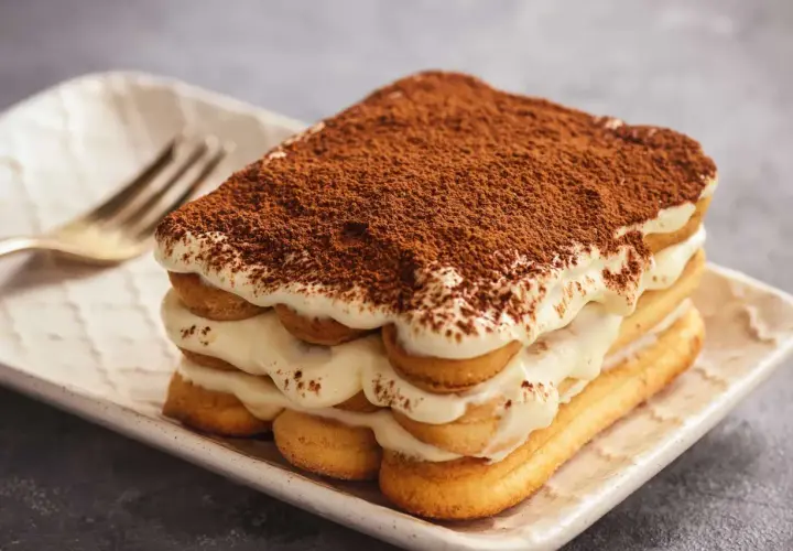 Pyszne tiramisu z kremem i biszkoptami, posypane kakao. Zastanawiasz się, jaki alkohol do tiramisu?