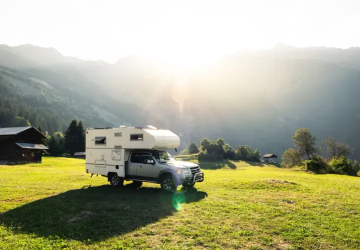 Camping-car dans un paysage montagneux ensoleillé, un endroit idéal pour le meilleur pays pour voyager en van.