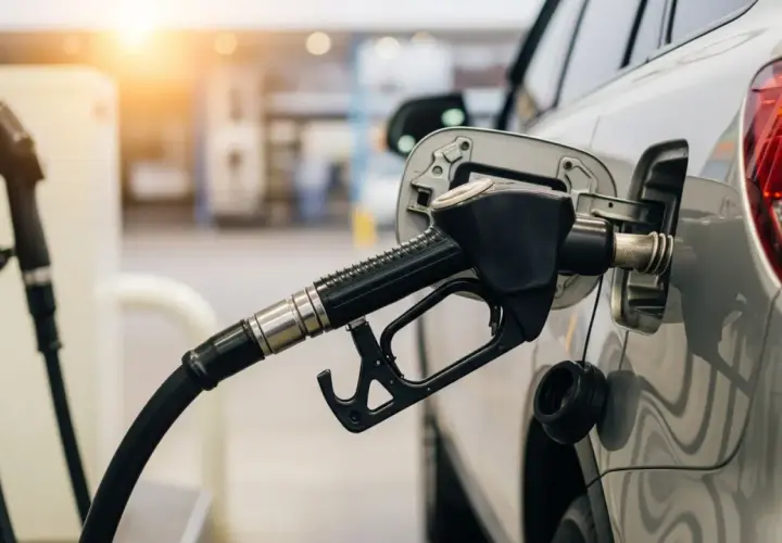 La manguera de una gasolinera surte el carburante de un coche.