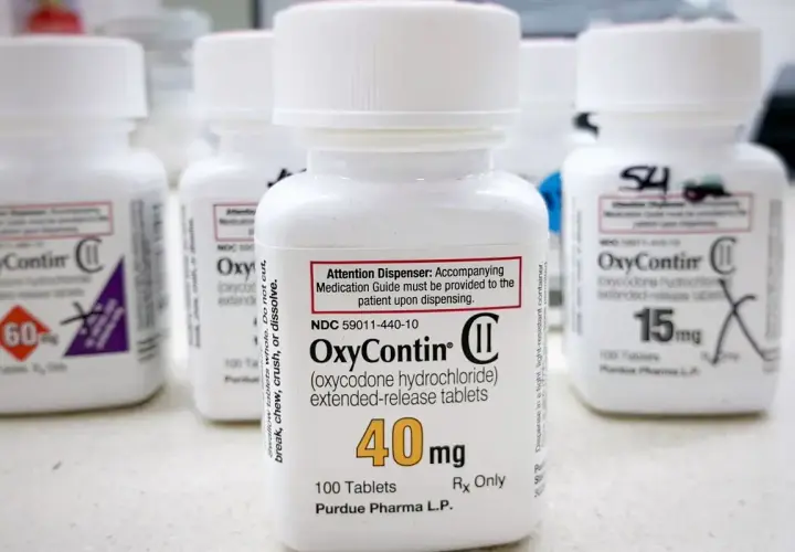 Butelki leku OxyContin, w tym jedna z dawką 40 mg, stoją na blacie.