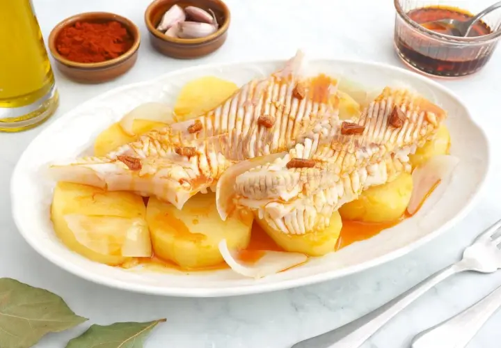 Raya a la gallega servida con patatas y cebolla, aderezada con aceite, pimentón y ajo.