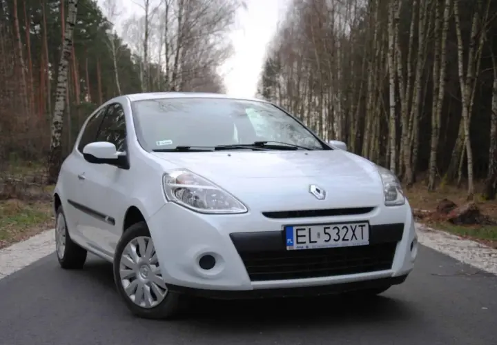 Biały Renault Clio 3 1.2 benzyna zaparkowany na leśnej drodze.