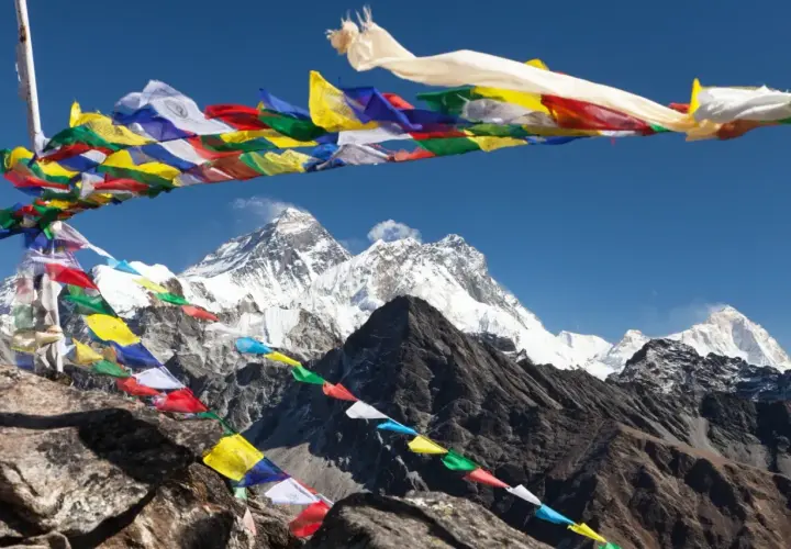 Modlitewne flagi powiewają na tle majestatycznego Everestu, który jest najwyższym szczytem na świecie.