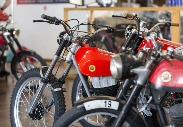 Motocicletas clásicas rojas, algunas con el número 19, que se consideran un ciclomotor.