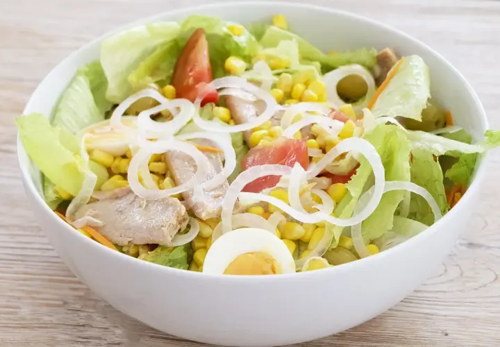 Deliciosa ensalada mixta con atún, huevo duro, maíz, tomate y cebolla. Fresca y completa.