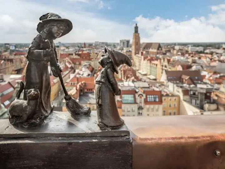 Dwa krasnale i kot na tle Wrocławia. Zastanawiasz się, ile jest krasnali we Wrocławiu?