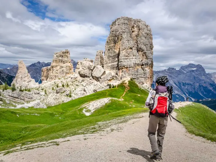 Wanderer auf einer **Cinque Torri Wanderung** mit Blick auf die markanten Felsformationen und die Dolomiten.