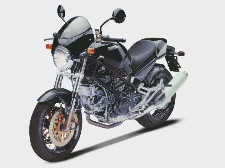 Czarny Ducati Monster z owiewką i sportowym wydechem. Klasyka motoryzacji, która wciąż budzi emocje.