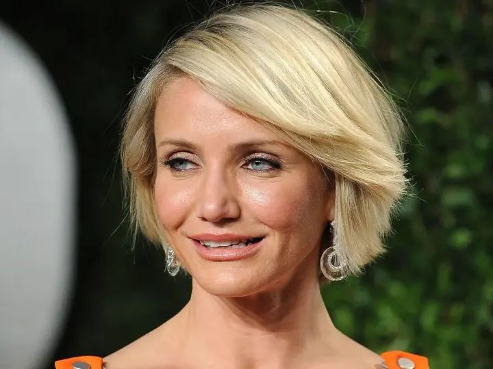 Cameron Diaz w stylowej fryzurze bob, idealnej dla okrągłej twarzy po 50. roku życia, z błyszczącymi kolczykami.