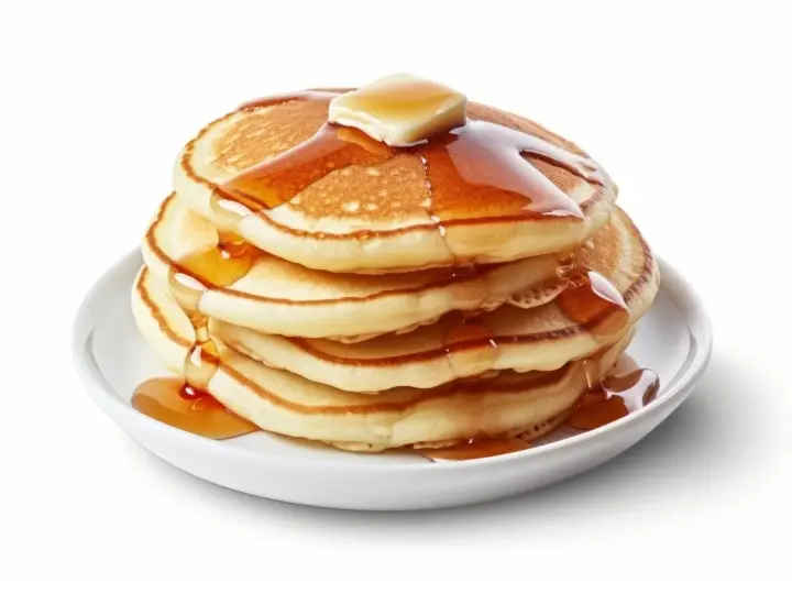 Pila de pancakes dorados con mantequilla y sirope cayendo. ¡Perfectos para tu receta de pancakes!