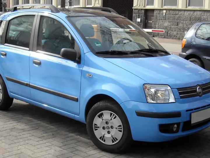 Una Fiat Panda blu parcheggiata su un selciato. Il suo peso è ideale per la città.