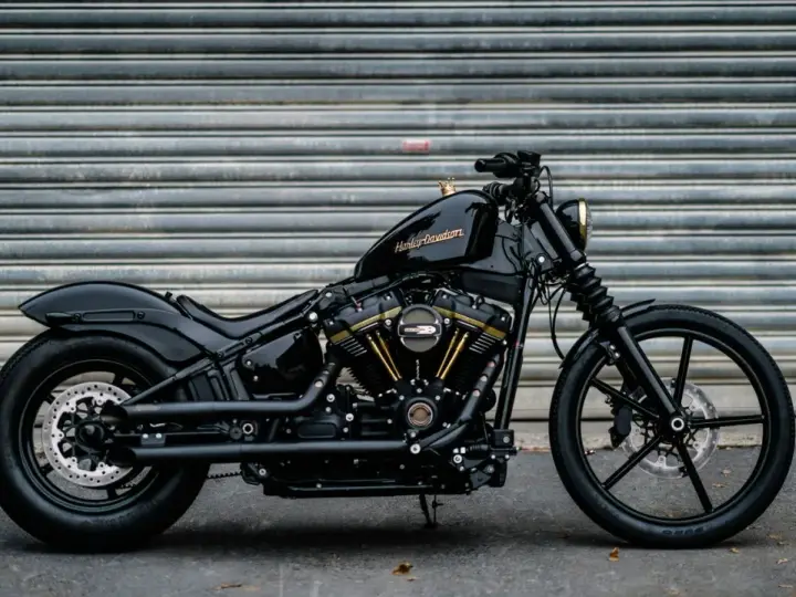 Czarny Harley-Davidson Dyna z błyszczącym lakierem i złotymi akcentami na silniku, gotowy do drogi.