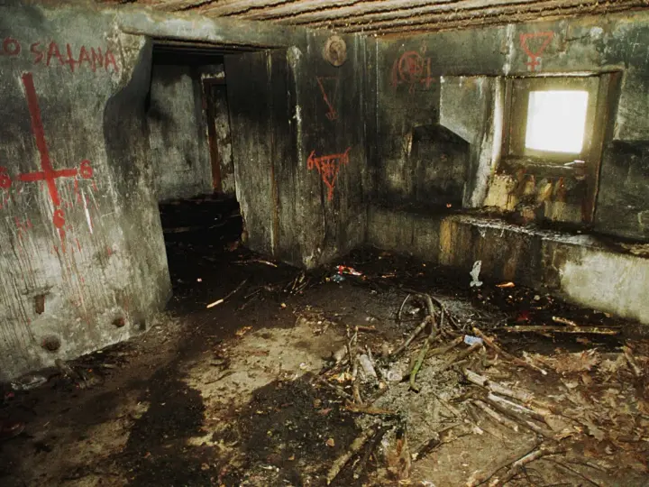 Wnętrze bunkra 44, ściany pokryte graffiti, na podłodze gruz i gałęzie.