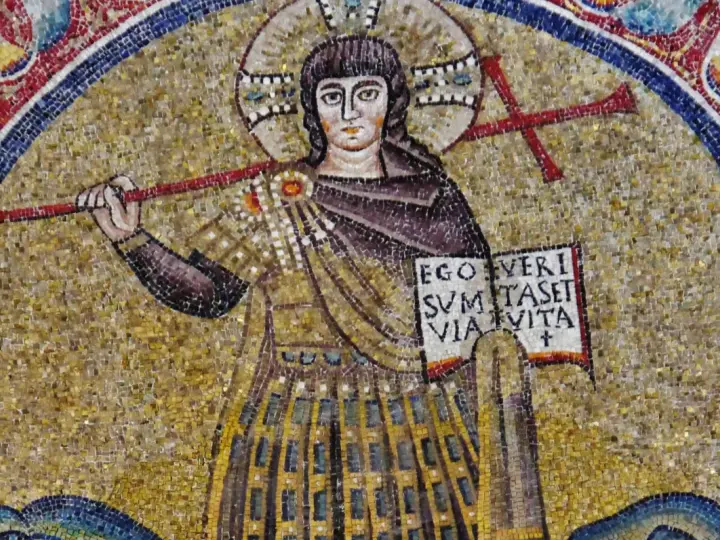 Mozaika przedstawia postać z krzyżem i księgą, symbolizującą boga.