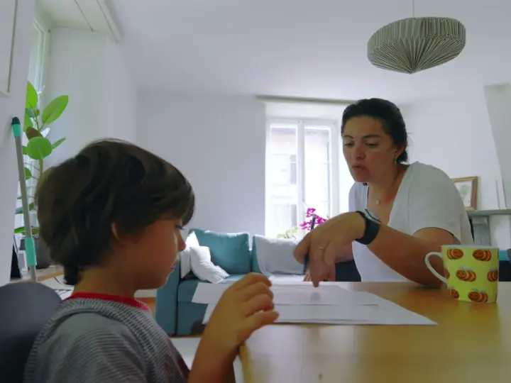 Mama tłumaczy synowi, co to są zgłoski, podczas wspólnej nauki.