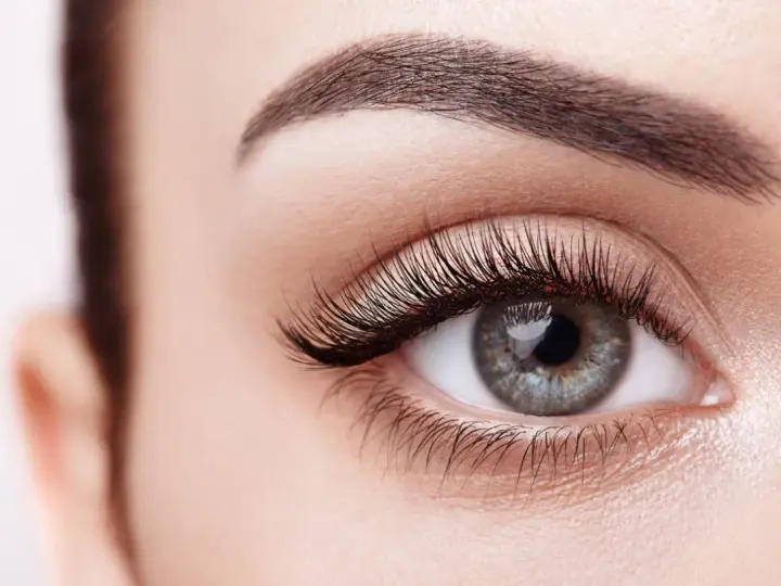 Ojo de mujer con pestañas largas y cejas definidas. Descubre cómo hacer crecer las pestañas para una mirada impactante.