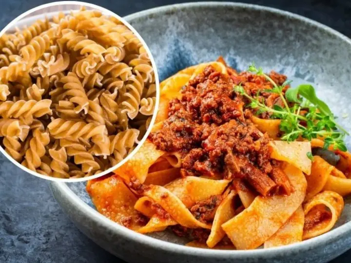 Pyszny makaron na redukcji z sosem bolognese. Widać też surowy makaron fusilli, idealny do zdrowych posiłków.