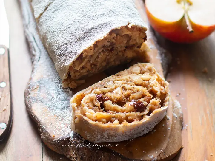 Un delizioso strudel di mele, cosparso di zucchero a velo, con un ripieno ricco di mele, uvetta e pinoli.