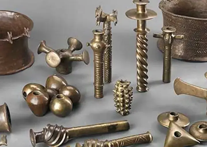 Colección de **herramientas de la edad de los metales**, incluyendo vasijas, soportes y objetos ornamentales de bronce y cobre.