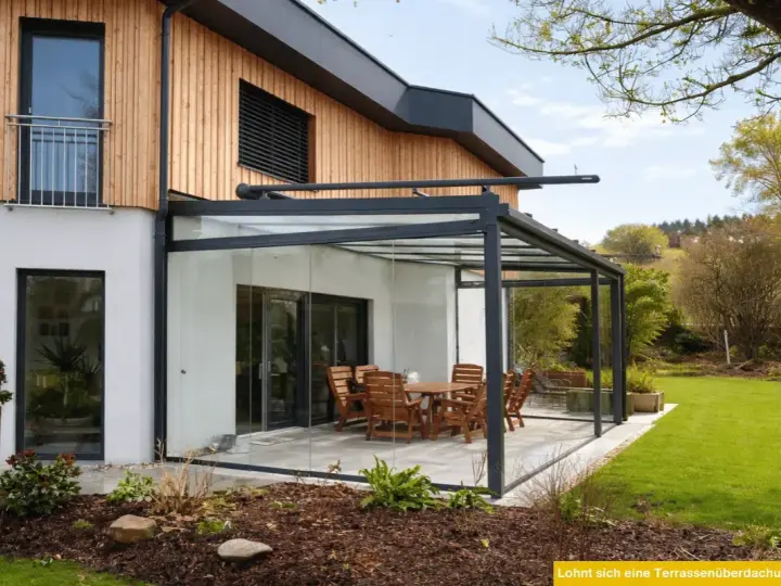 Moderne Glasdach-Terrasse mit Holztisch und Stühlen. Nachteile wie Hitzeentwicklung im Sommer sind zu bedenken.