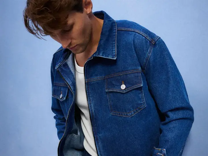 Mężczyzna w dżinsowej kurtce, idealnej do stworzenia uniwersalnej szafy kapsułowej. Klasyczny krój i niebieski denim.