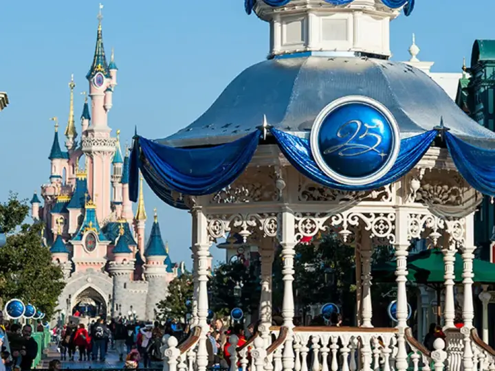 El castillo rosa de Disneyland Paris se alza majestuoso, con un quiosco decorado para celebrar el 25 aniversario.