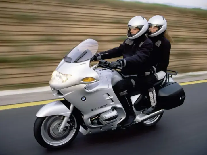 Para podróżuje na srebrnym BMW R 1100 RT. Choć motocykl ten ma swoje wady, podróż wygląda na komfortową.
