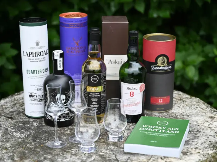 Laphroaig Aussprache: Eine Auswahl schottischer Single Malts, darunter Laphroaig Quarter Cask, Ardbeg 8, Bunnahabhain 12 und mehr, bereit für eine Verkostung.