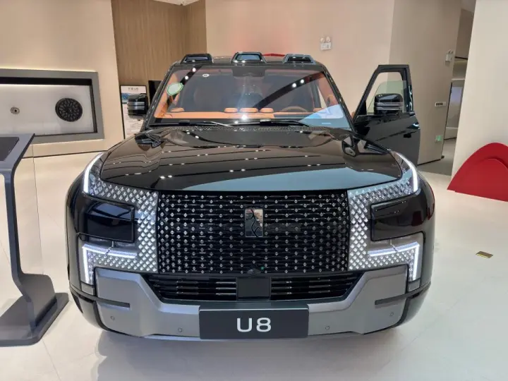 Czarny BYD Yangwang U8 z otwartymi drzwiami, prezentujący imponujący grill i nowoczesne reflektory.