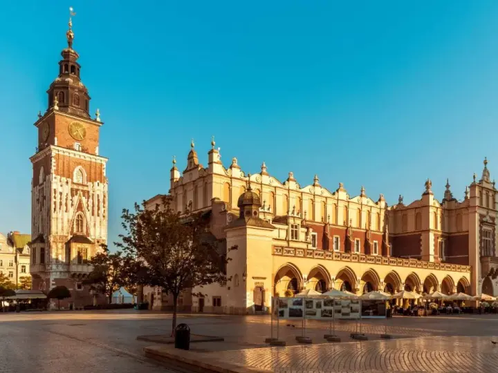 Rynek Główny w Krakowie, idealne miejsce na city break. Sukiennice i wieża Ratuszowa w słońcu.