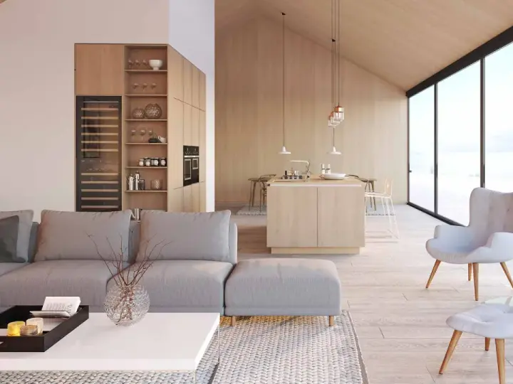 Jasny, przestronny salon z aneksem kuchennym w stylu skandynawskim. Drewniane wykończenia, duża sofa i kominek tworzą przytulną atmosferę.