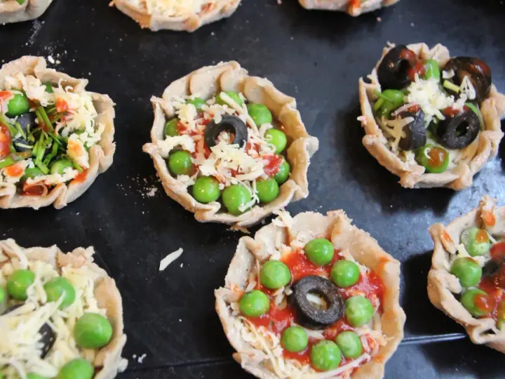 Mini pizze z groszkiem, oliwkami i serem, idealne na podwieczorek.
