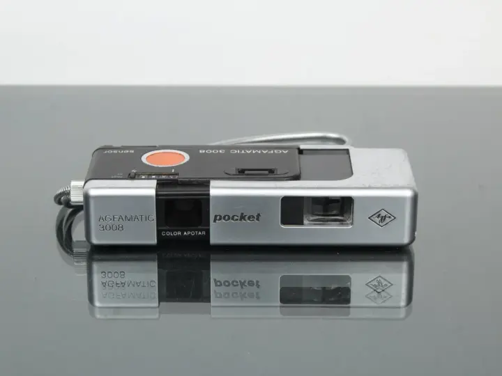 Srebrny aparat Agfamatic 3008 z napisem "pocket" i logo Agfa. Idealny do uchwycenia wspomnień.