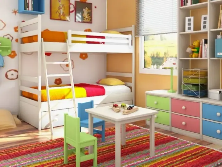 Cameretta bambino 6 anni con letto a castello, scrivania, tappeto colorato e libreria piena di giochi e libri.