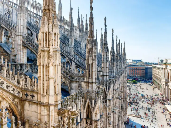 Majestatyczne iglice katedry Duomo w Mediolanie w listopadzie, z widokiem na tętniący życiem plac poniżej.