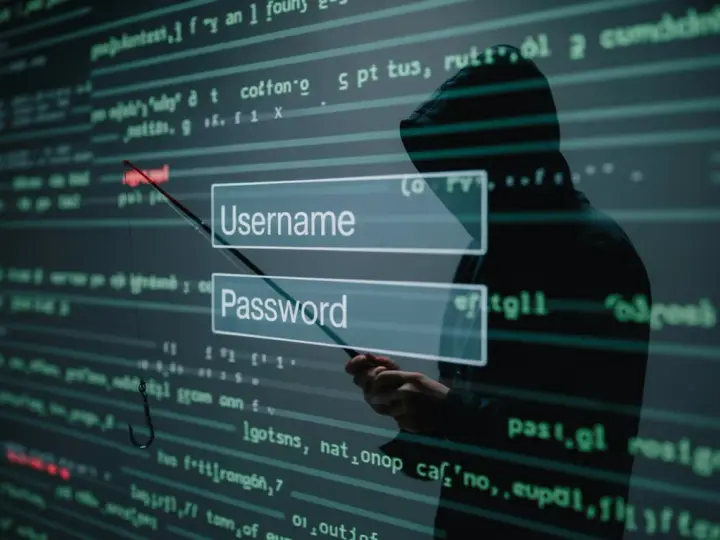 Sylwetka hakera w kapturze celuje wędką z haczykiem w pola logowania "Username" i "Password", symbolizując atak socjotechniczny.