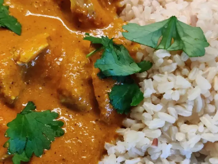En krämig kycklingrätt med ris, perfekt för ett snabbt tikka masala recept. Garnerad med färsk koriander.