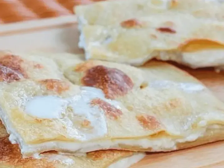 Focaccia di Recco, sottile e dorata, con il suo ripieno filante di formaggio fresco.