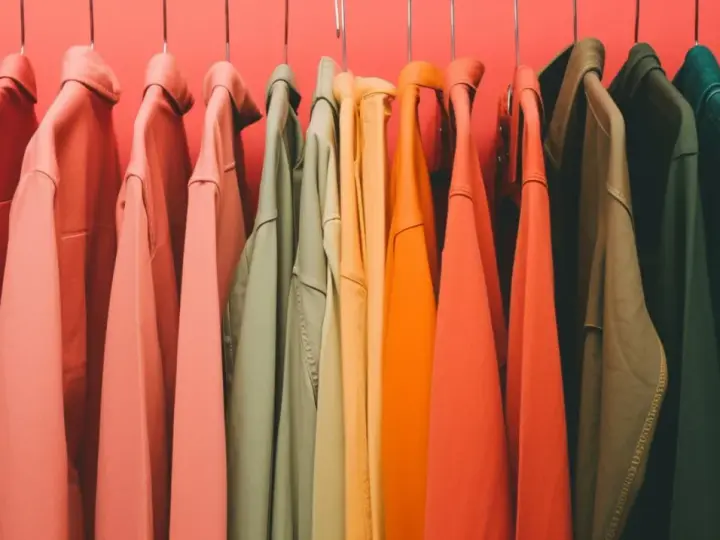 Percheros con ropa de tonos cálidos y fríos, un arcoíris de color verano listo para usar.