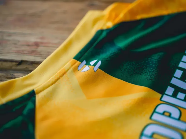 Nahaufnahme eines gelb-grünen **jersey polyester** mit einem weißen Logo.