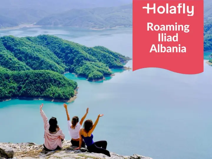 Tre amiche ammirano un lago turchese in Albania, con la scritta "Holafly Roaming Iliad Albania".