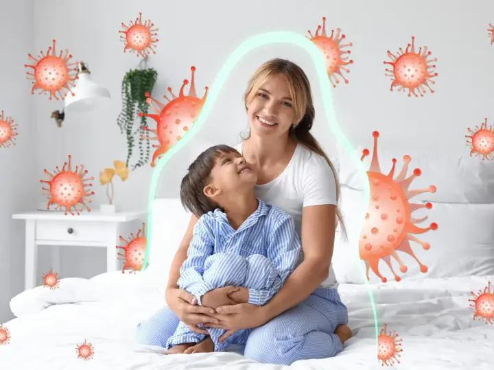 Mama tuli dziecko, które miało kaszel w nocy. Wokół nich wirusy, ale chroni je zielona bariera.