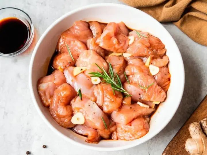 Troceado de pollo marinado con ajo y romero, listo para deliciosas recetas.