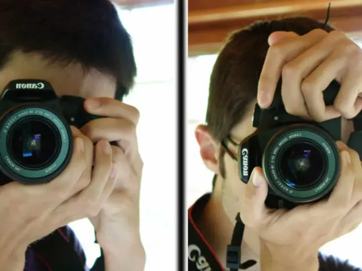 Un jeune homme apprend à photographier, tenant un appareil Canon pour capturer son reflet.